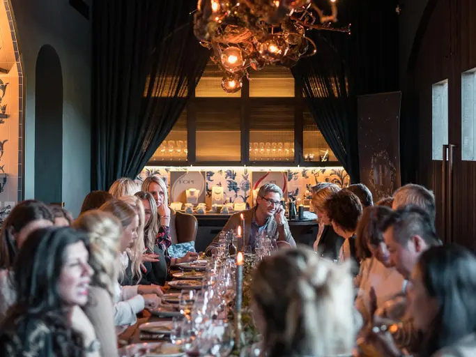 Eine Silvester Gala-Dinner Gesellschaft, ca. 20 Personen sitzen an einem festlich gedeckten Tisch am Silvesterabend.
