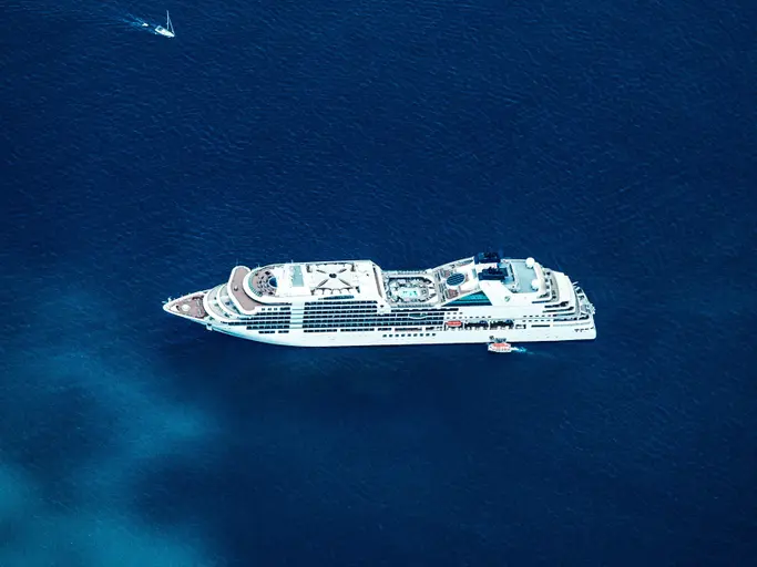 Ein Kreuzfahrtschiff aus der Vogelperspektive auf dem blauen Ozean