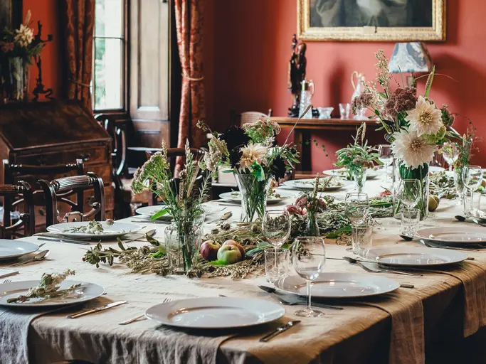 Eine festlich gedeckte Tafel mit Blumendekoration an einem Silvesterabend zu Hause