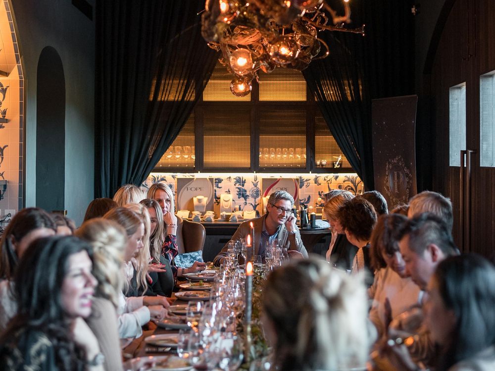 Eine Silvester Gala-Dinner Gesellschaft, ca. 20 Personen sitzen an einem festlich gedeckten Tisch am Silvesterabend.